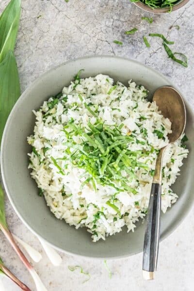 white rice with ramps on the side in a grey bowl