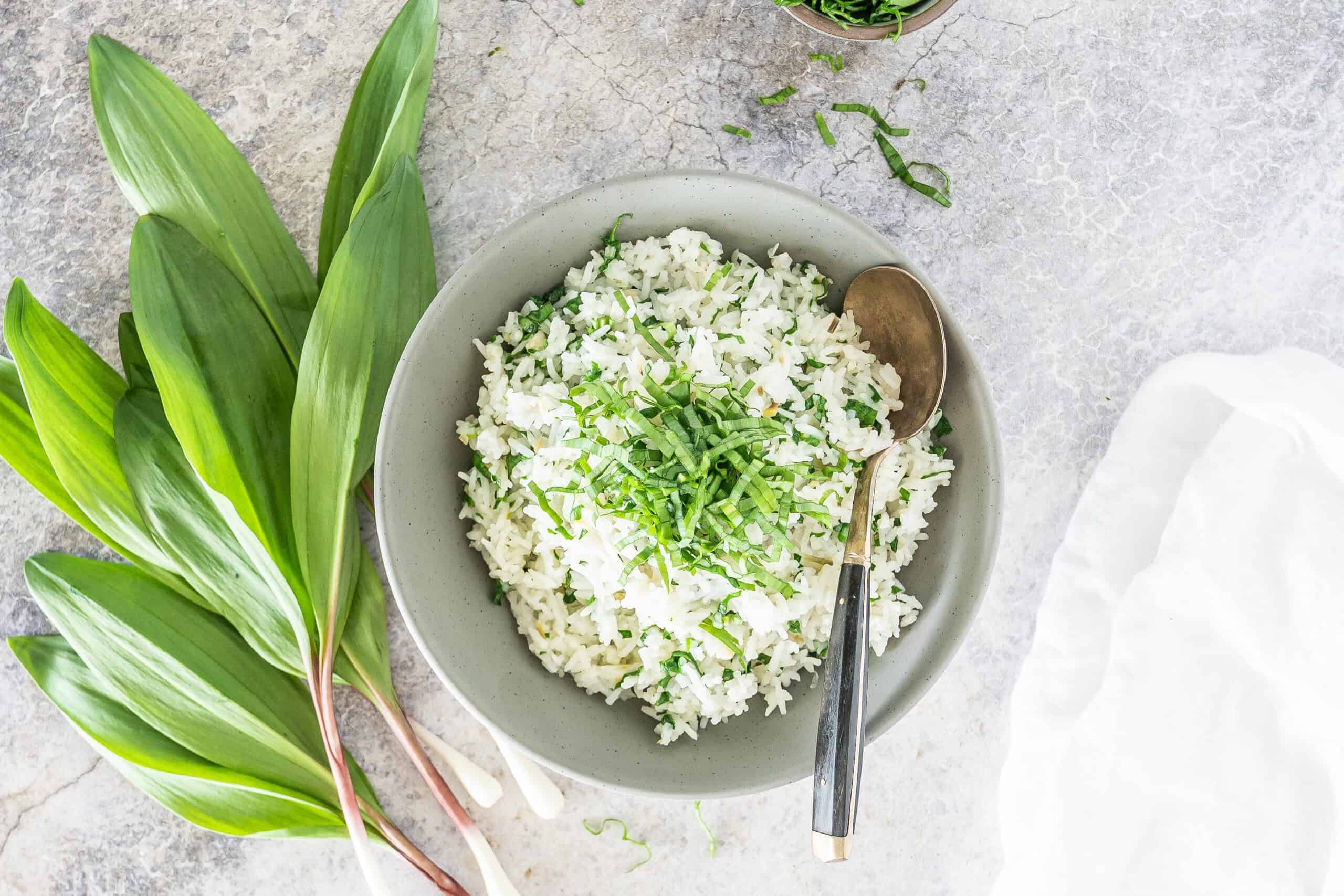 white rice with ramps on the side in a grey bowl