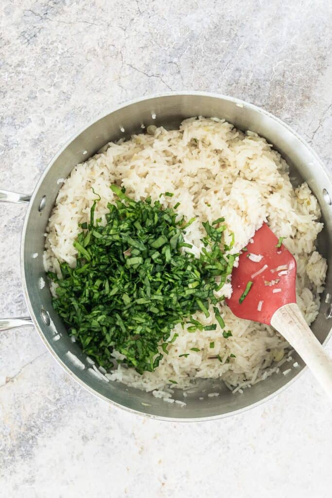 medium sauce pan of rice with chopped ramp greens on top