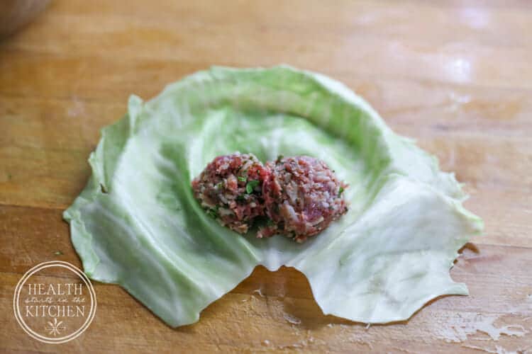 Meat filling placed near the base of a cabbage leaf