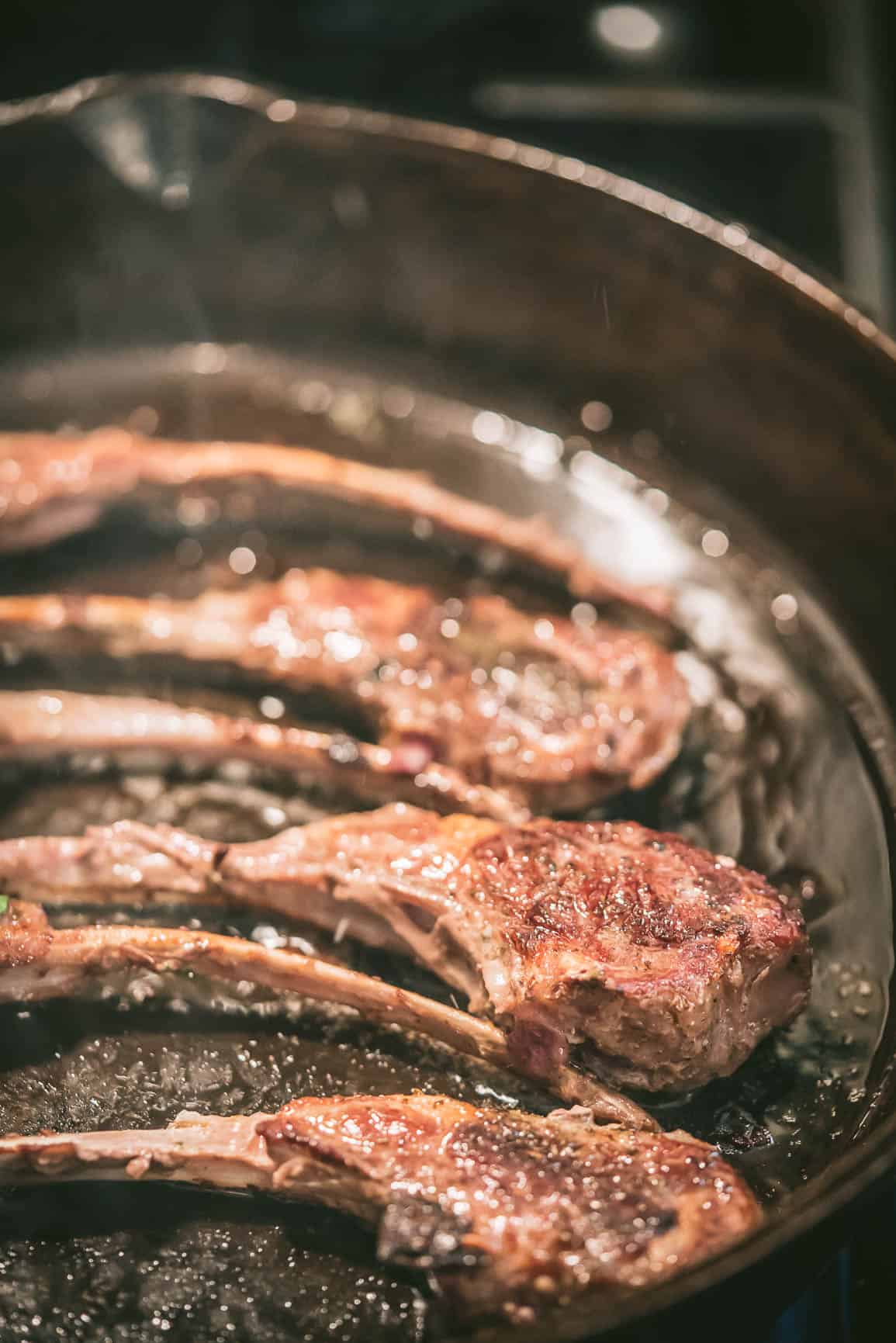 Lamb Chops cooking in a cast iron skillet