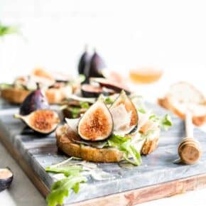 This flavorful Fig Bruschetta is an easy, yet delicious appetizer. It’s also perfect for dinner parties, picnics, and any occasion where you want to serve something that is simple yet sophisticated. Toasted bread rubbed with garlic, topped with fresh figs, prosciutto, arugula and features Copper Kettle Cheese, drizzled with honey