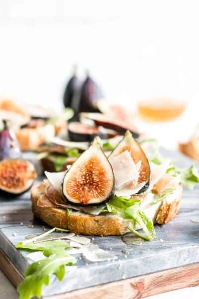 This flavorful Fig Bruschetta is an easy, yet delicious appetizer. It’s also perfect for dinner parties, picnics, and any occasion where you want to serve something that is simple yet sophisticated. Toasted bread rubbed with garlic, topped with fresh figs, prosciutto, arugula and features Copper Kettle Cheese, drizzled with honey