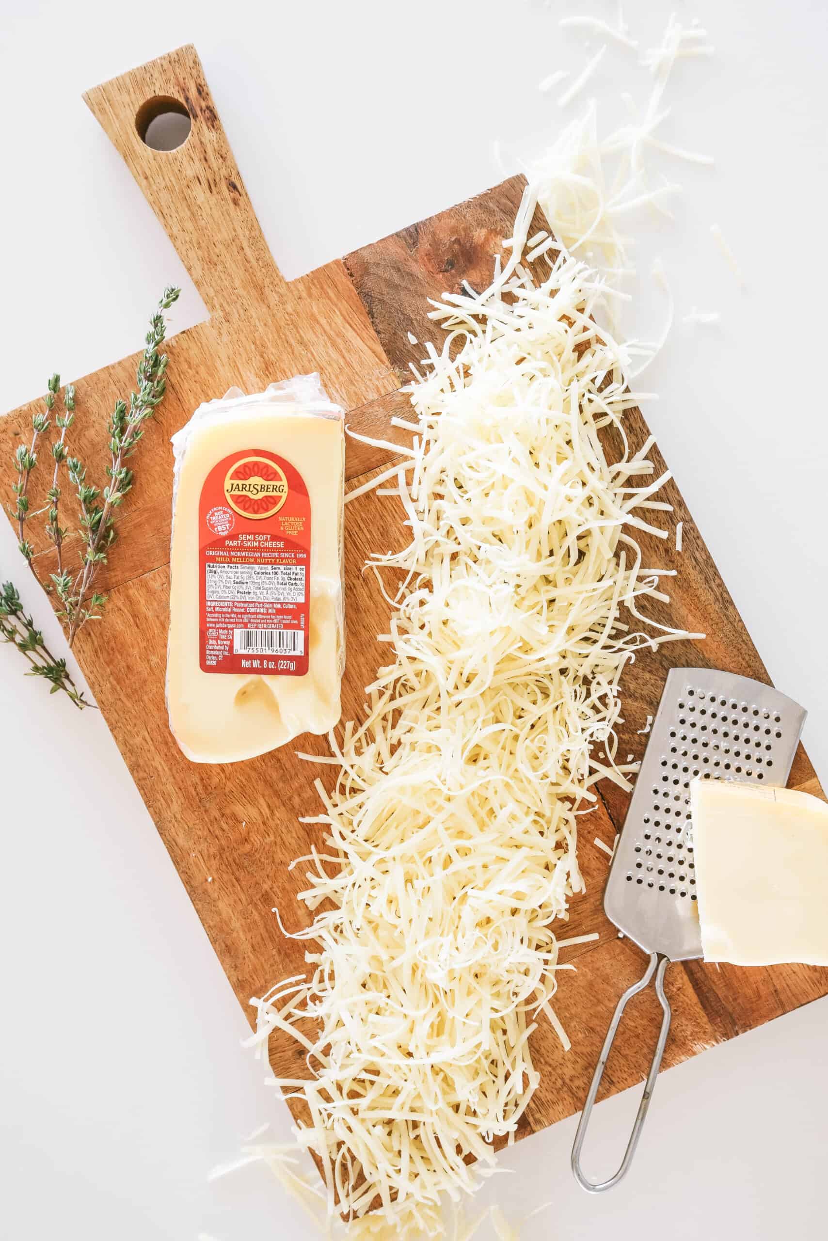grated Jarlsberg Cheese on a wooden cutting board