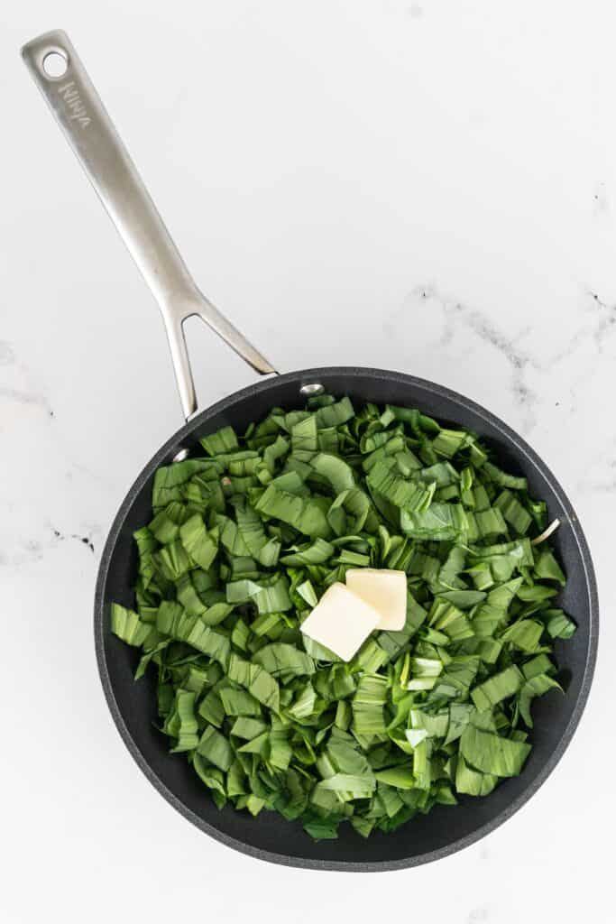 sliced ramp greens with butter in a non stick skillet