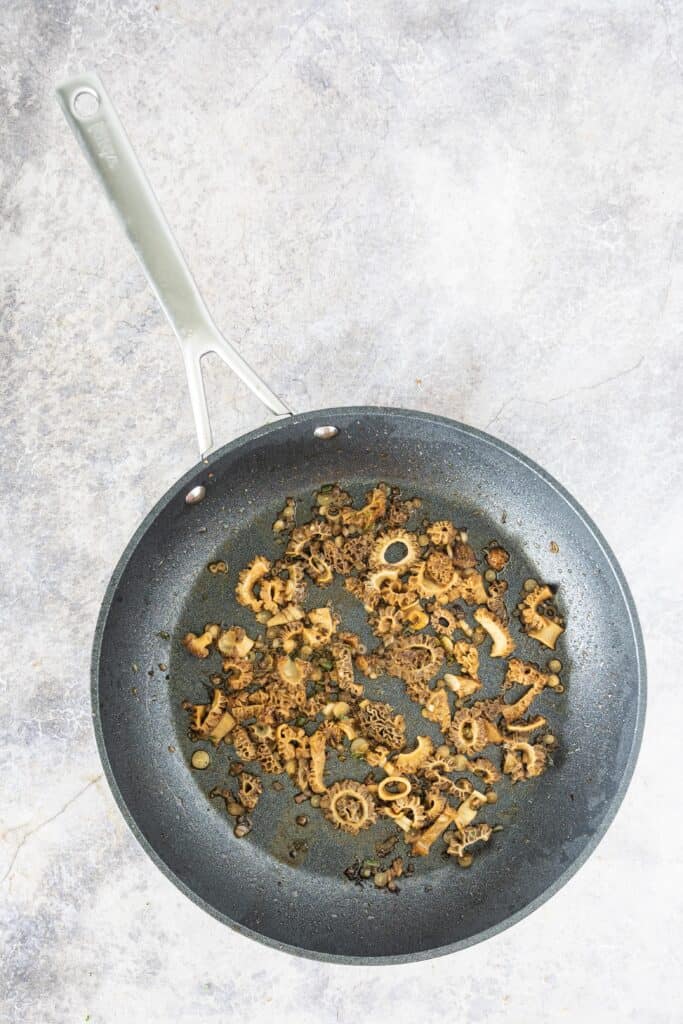 skillet with chopped ramp bulbs and morel mushrooms, sautéed in butter