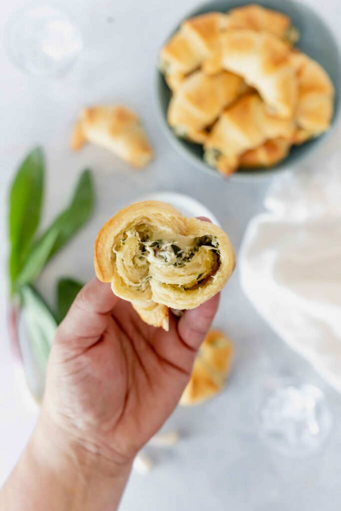 close up of a crescent roll filled with ramps cream cheese and gruyere