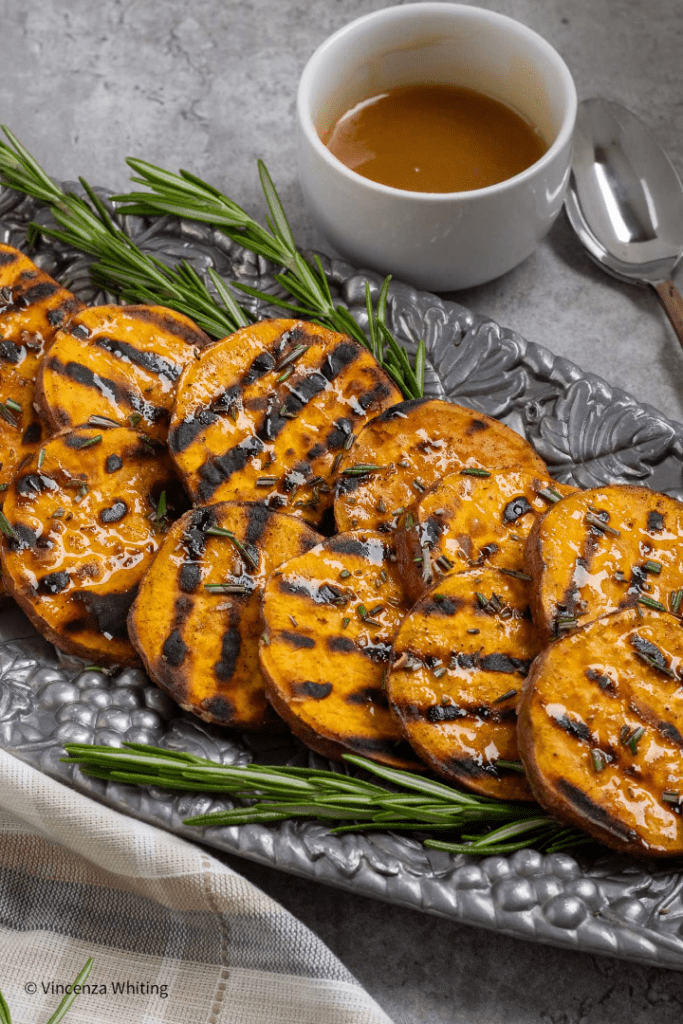 Grilled Sweet Potatoes are easy, delicious, and healthy vegetables that you can enjoy all year long.  They are the perfect side dish whether you are planning a summer barbecue, or you want to add them to your Thanksgiving menu.  The char marks from the grill give the sweet potatoes a smoky flavor, while the rosemary hot honey drizzle adds a little sweet and spicy kick.