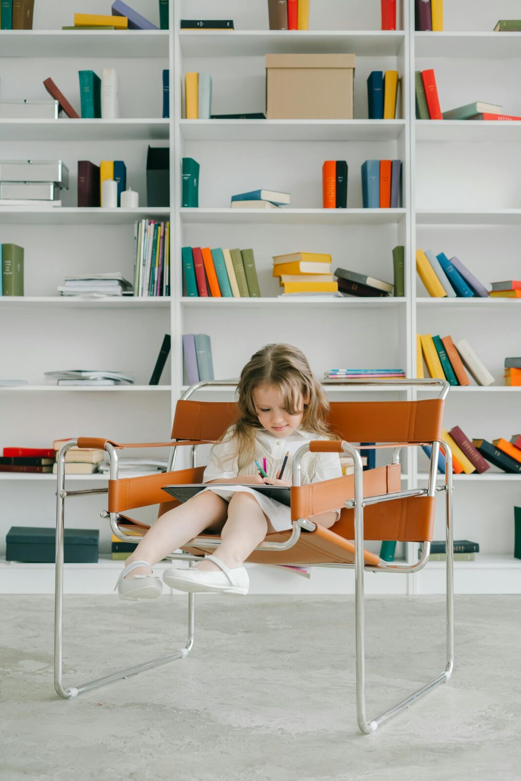 Young girl sitting in a chair, reading in a colorful library. Bright and educational atmosphere.