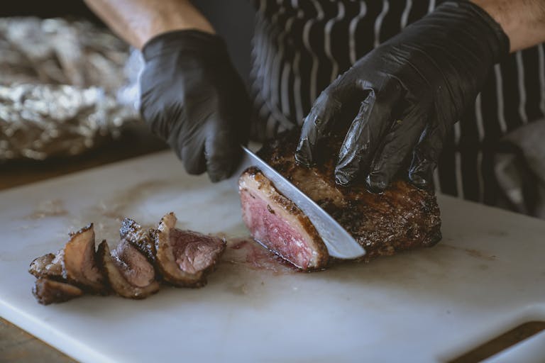 Chef slicing a perfectly cooked steak on a chopping board, showcasing juicy and delicious meat.