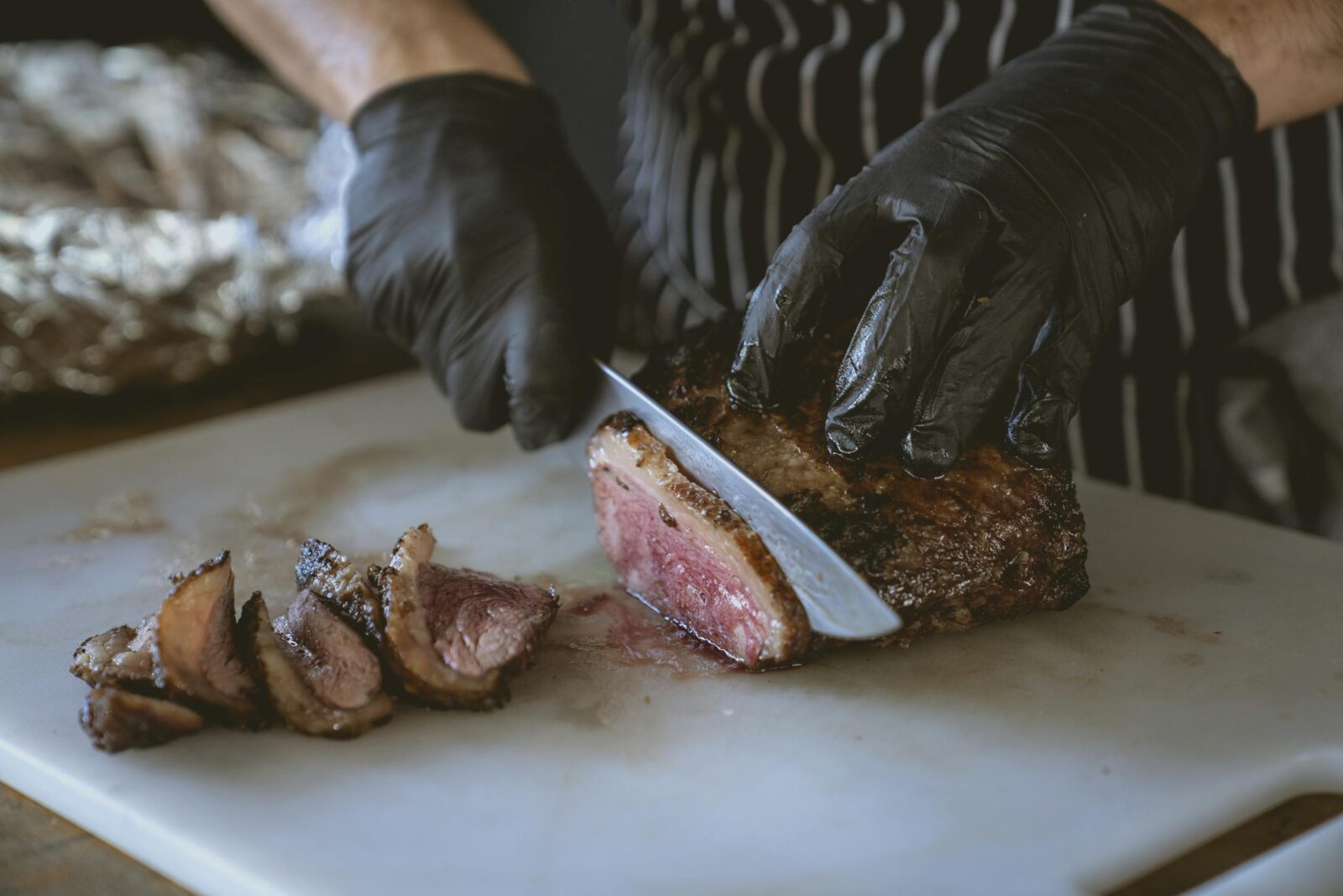 Chef slicing a perfectly cooked steak on a chopping board, showcasing juicy and delicious meat.