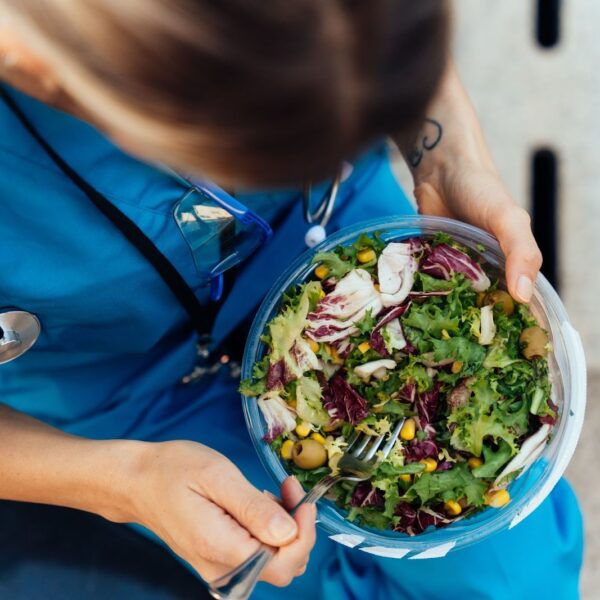 Healthcare worker eating a salad.