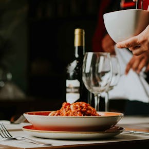 A sophisticated Italian dining scene featuring spaghetti and wine, perfect for a cozy evening out.