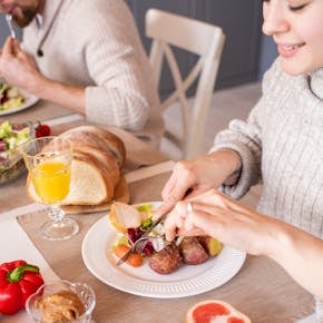 A cozy family breakfast scene with fresh fruits, vegetables, and orange juice.