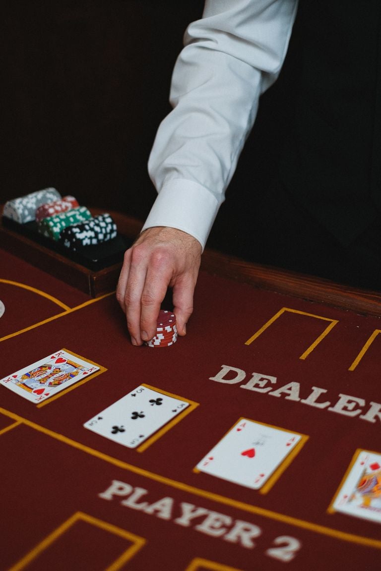 Elegant setup of a casino blackjack table with a dealer handling chips, perfect for gambling themes.