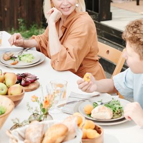 A mother and son enjoying a healthy lunch outdoors on a sunny day.