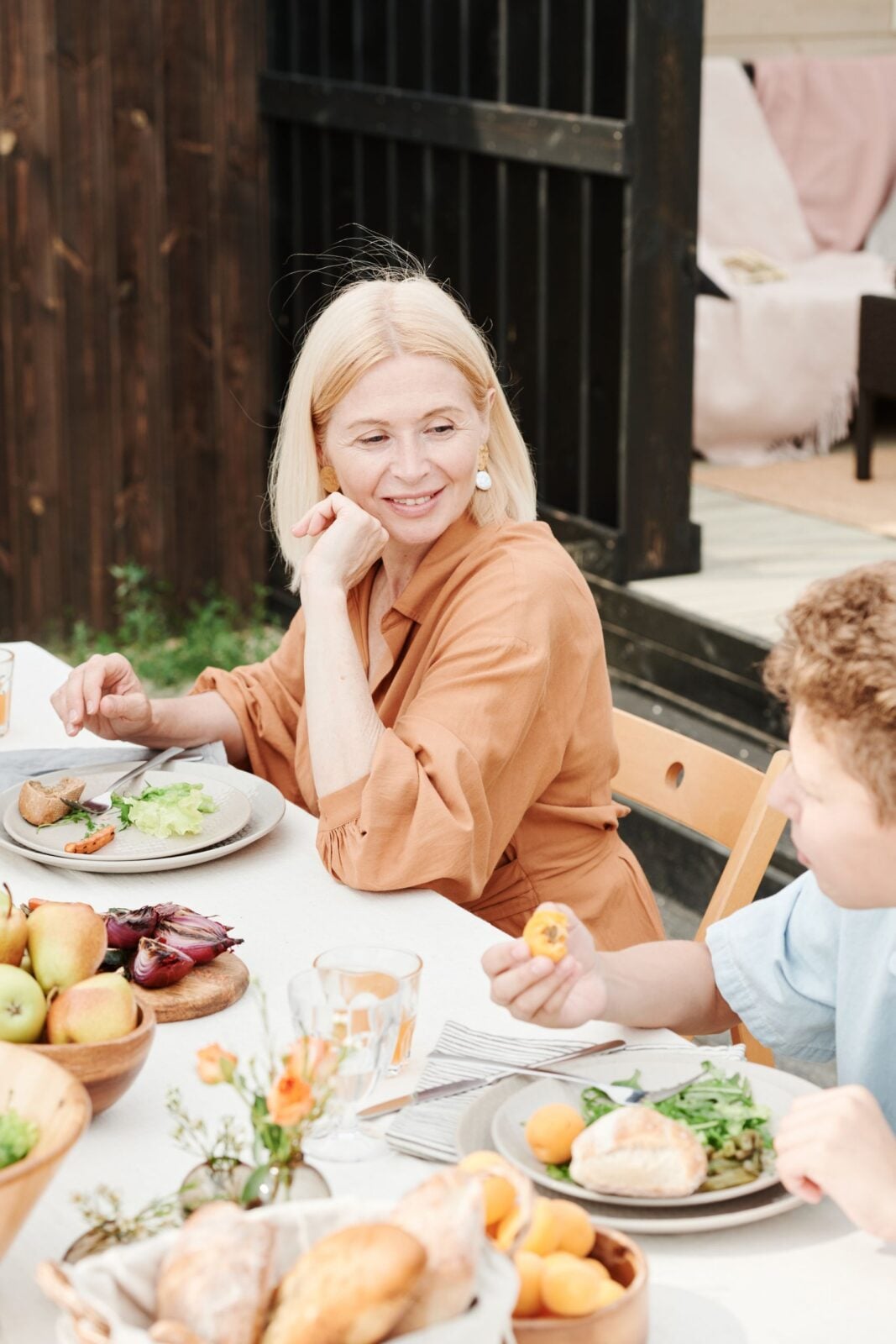 A mother and son enjoying a healthy lunch outdoors on a sunny day.