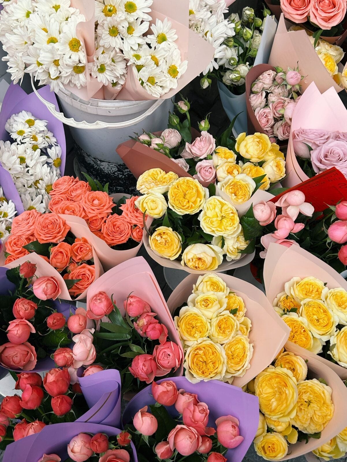A colorful assortment of flower bouquets including daisies and roses at a market in Azerbaijan.