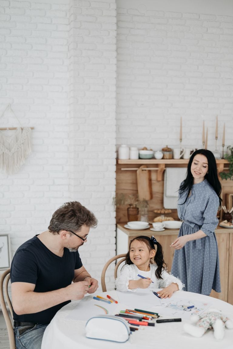 A happy family enjoying creative drawing time together in a cozy home setting.