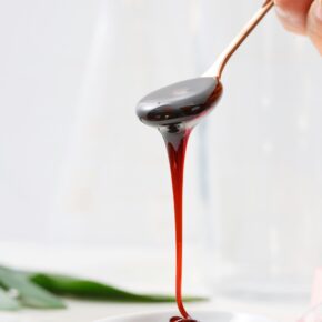 homemade elderberry syrup drippig off a spoon