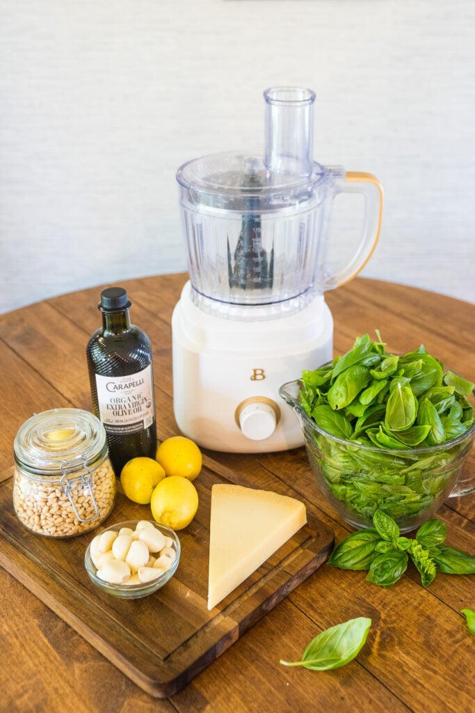 Food processor with basil, pine nuts, Parmesan, garlic, lemon and olive oil