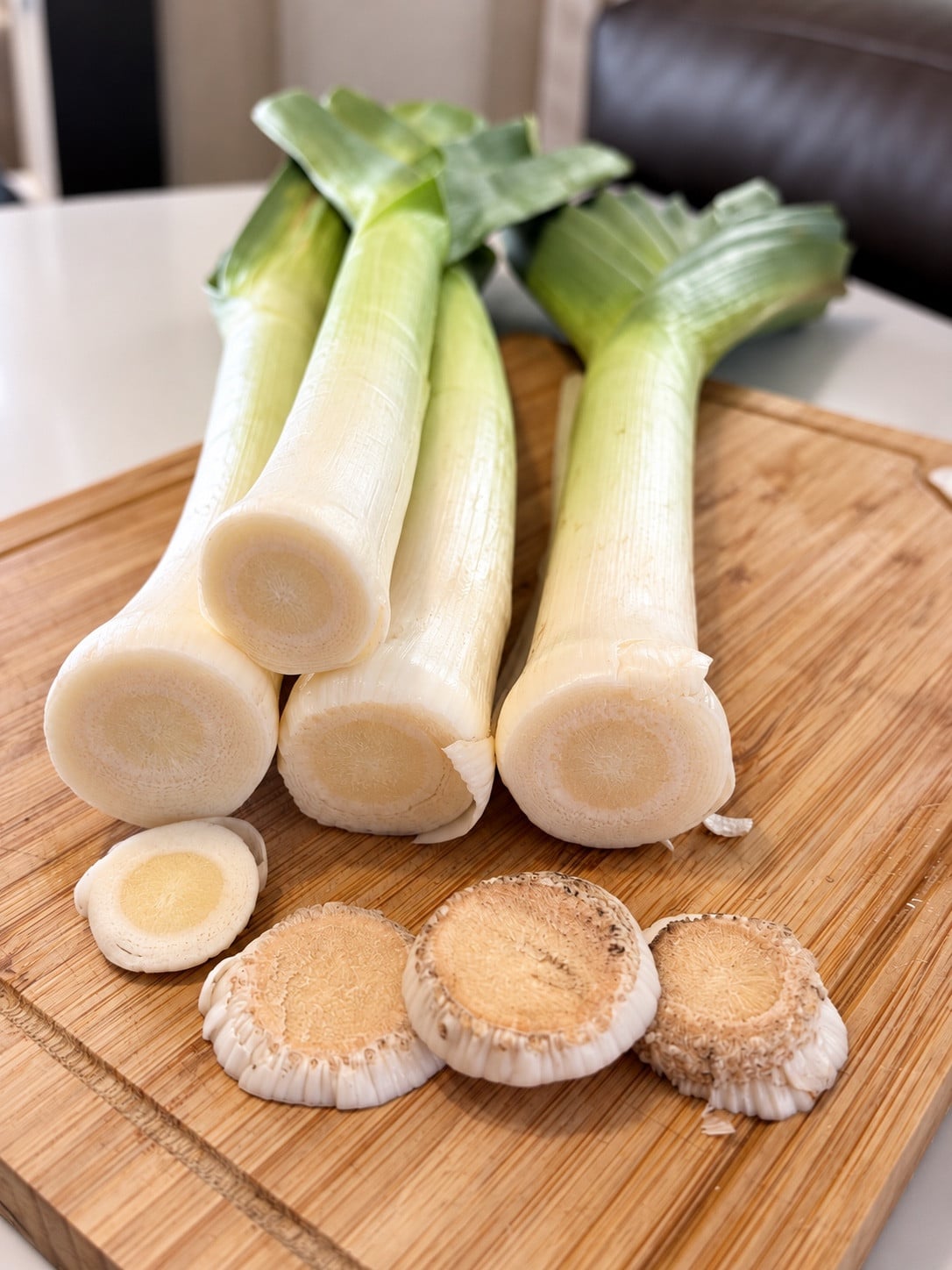 Trimmed leeks and discarded tops on a cutting board