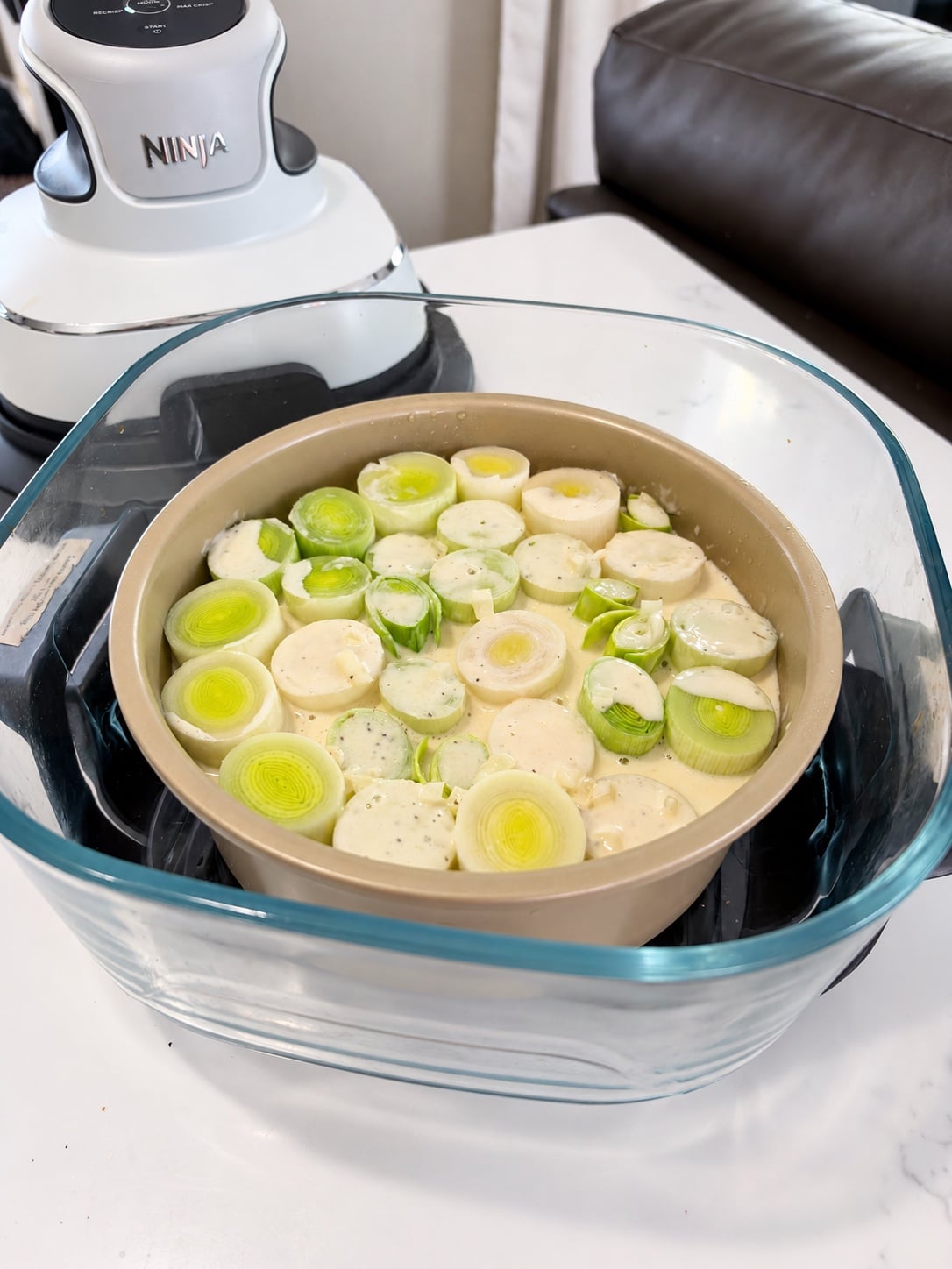 Pan of leeks in cream sauce inside the Ninja Crispi glass container