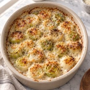 Air fryer leek gratin with browned upright leek rounds in creamy Parmesan sauce