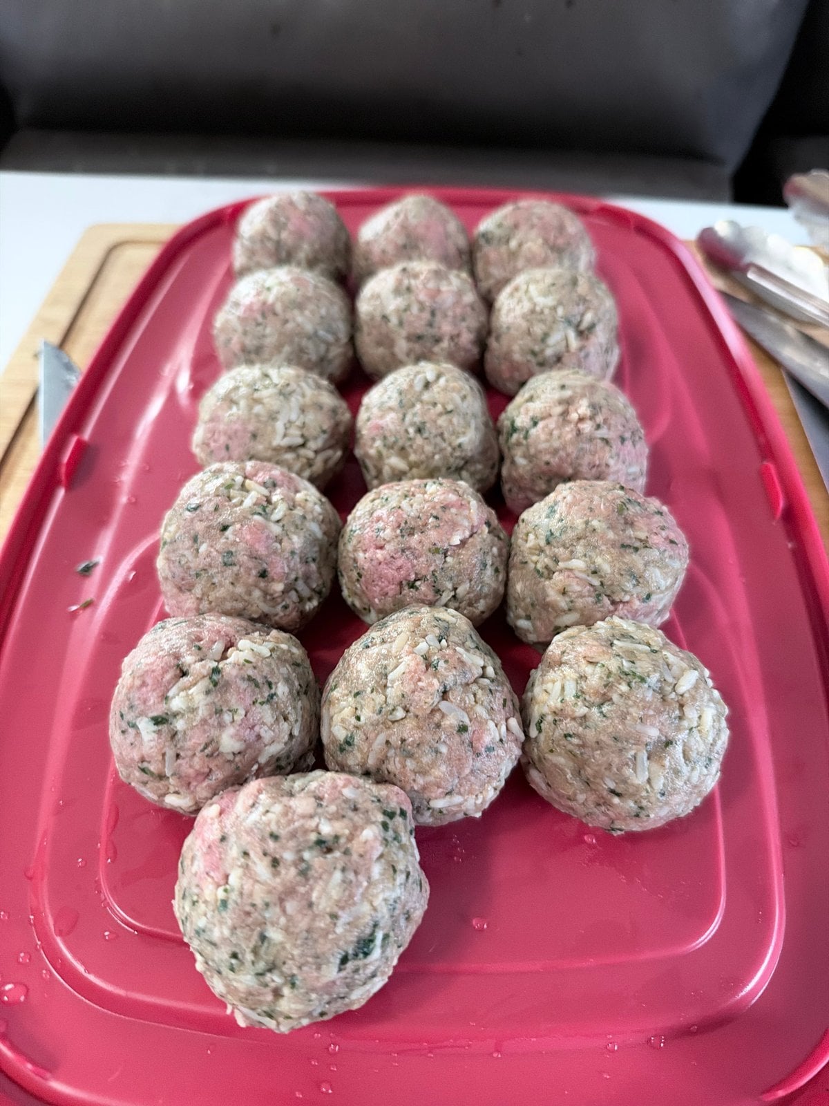 Raw beef and cooked rice porcupine meatballs on a red tray